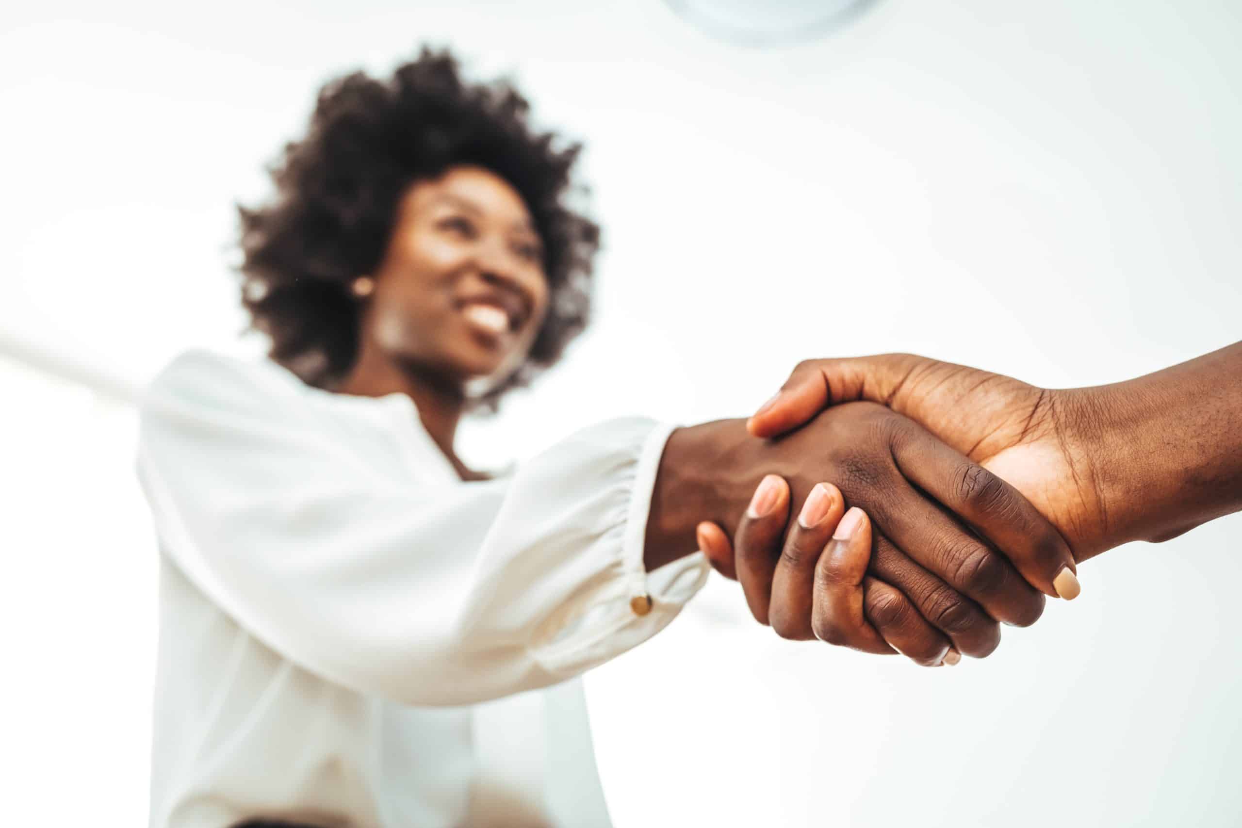 Two people shaking hands during a consultation