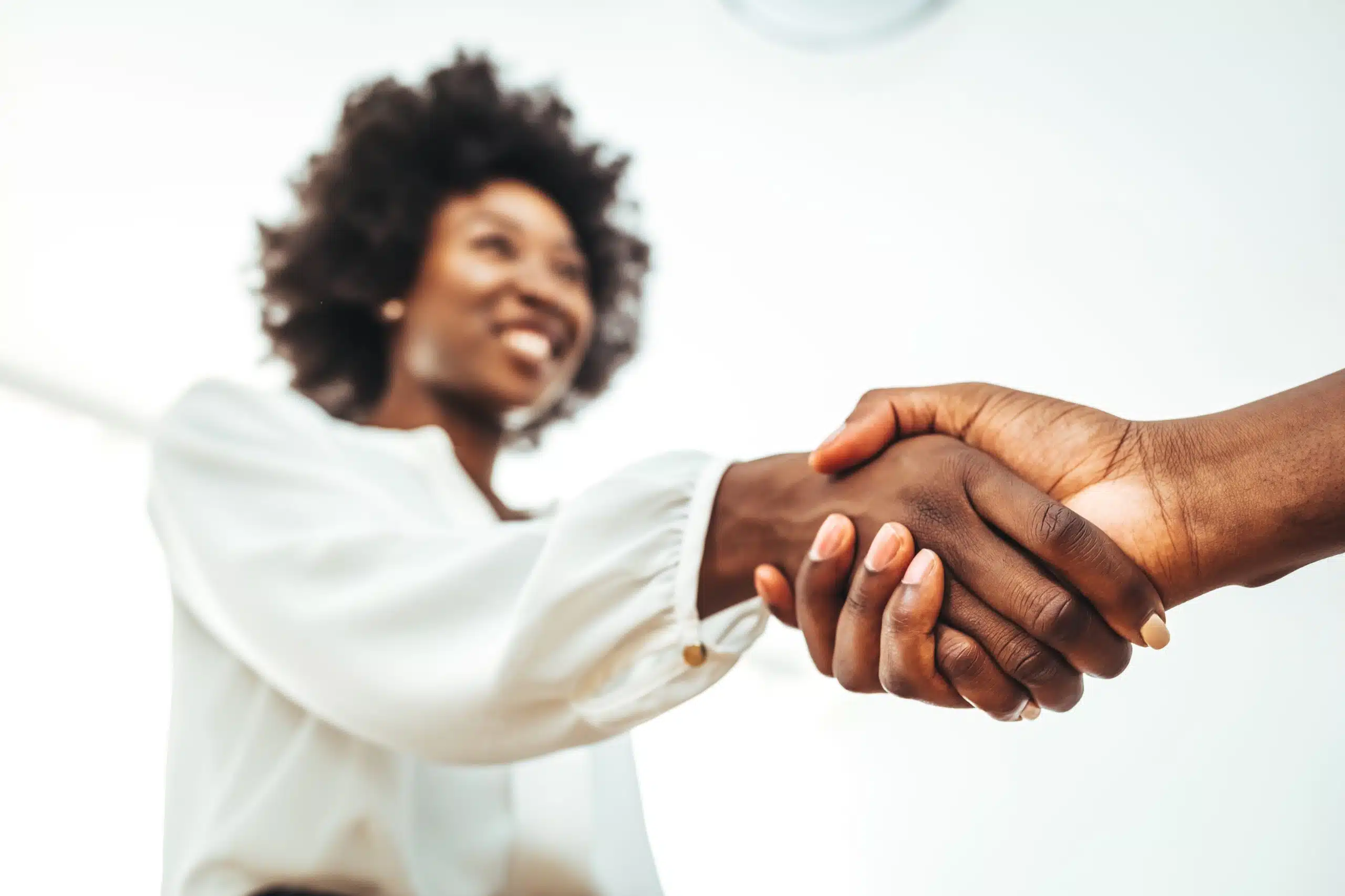 Two people shaking hands during a consultation