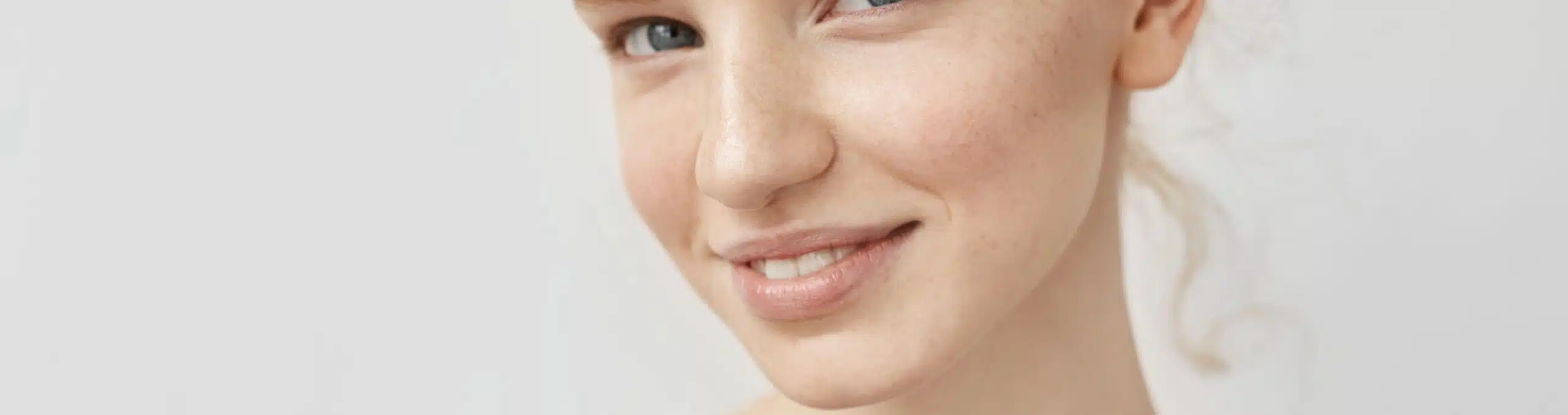 Close-up portrait of a smiling red-haired woman with freckles