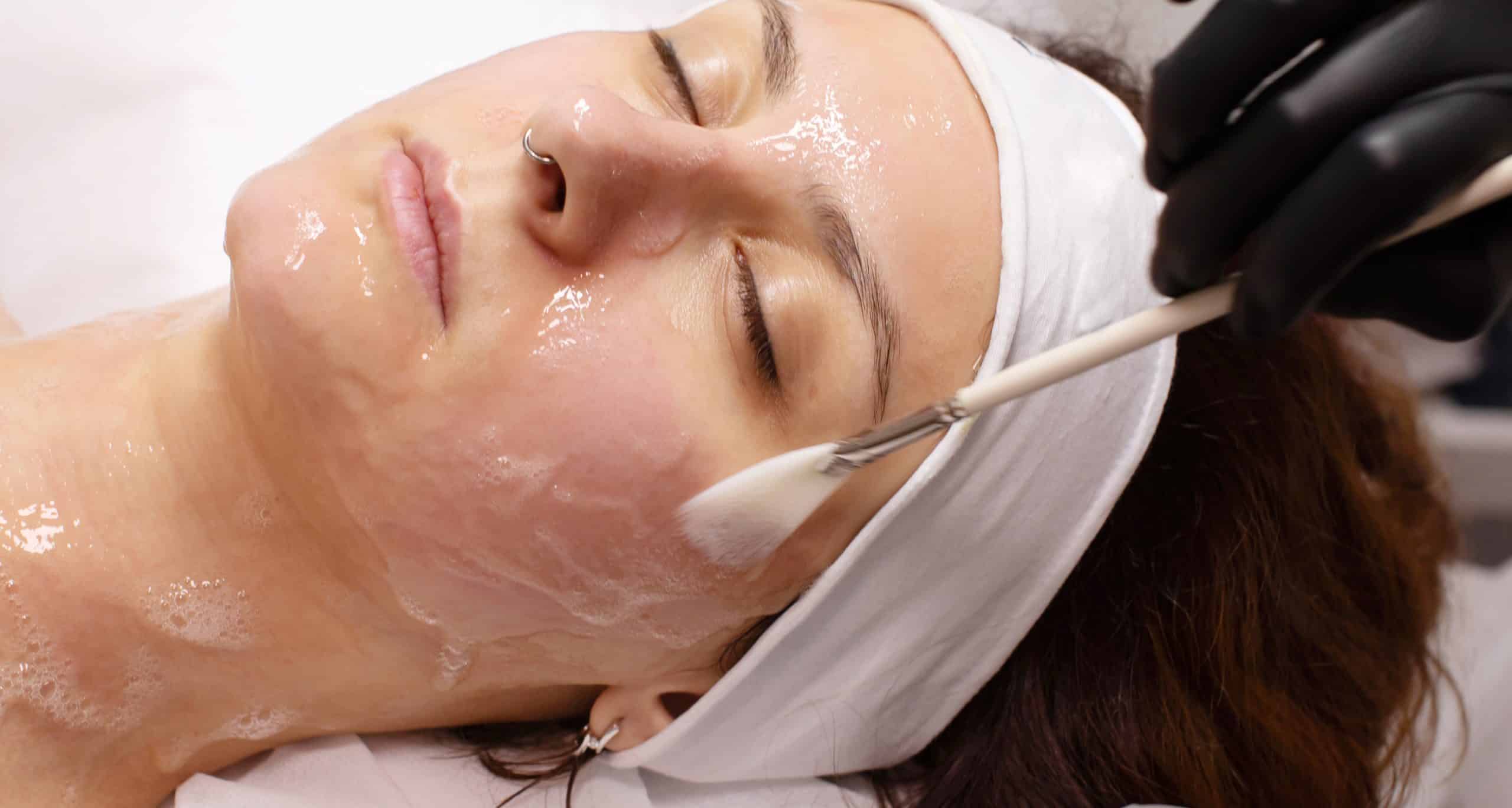 Cosmetologist applying chemical peel product client s face salon 1