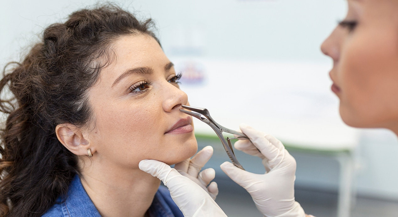 Doctor otorhinolaryngologist checking nose with otoscope patient hospital nasal congestion sinusitis allergy concept 1 1