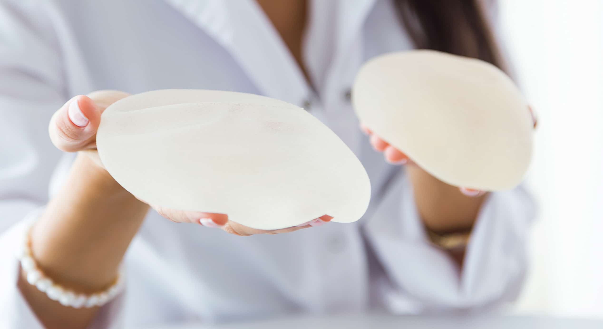 Female doctor choosing mammary prosthesis office 1 1