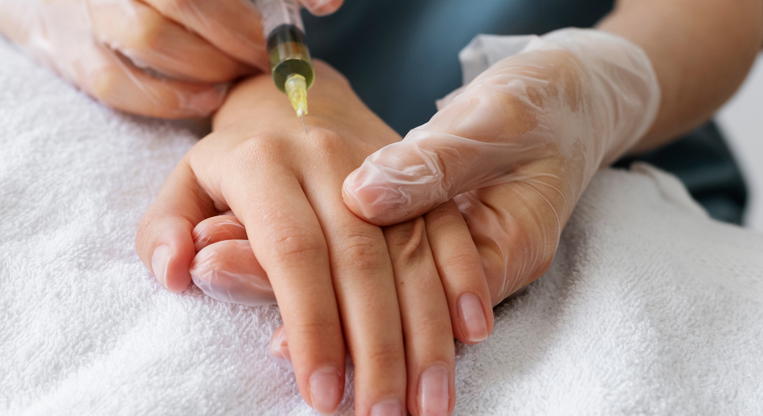 Low angle healthcare professional injecting hand 1
