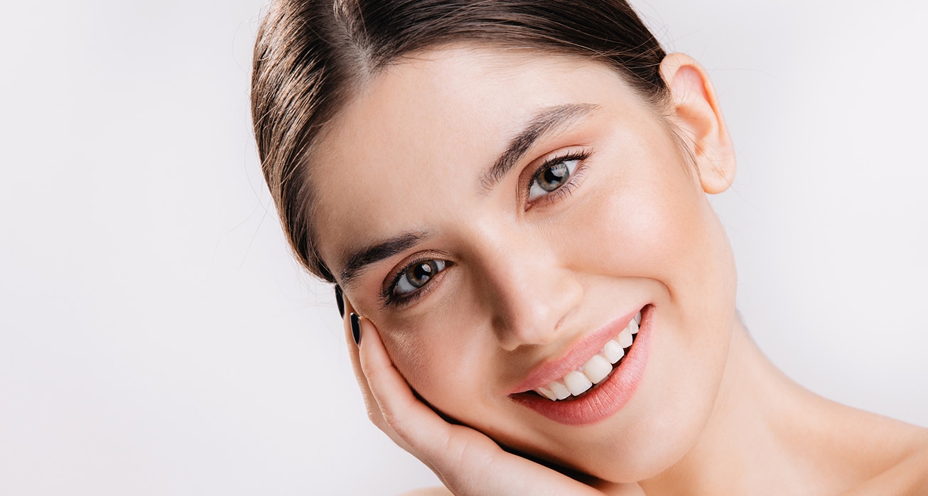 Portrait smiling girl with healthy skin cute dark haired woman white wall 1