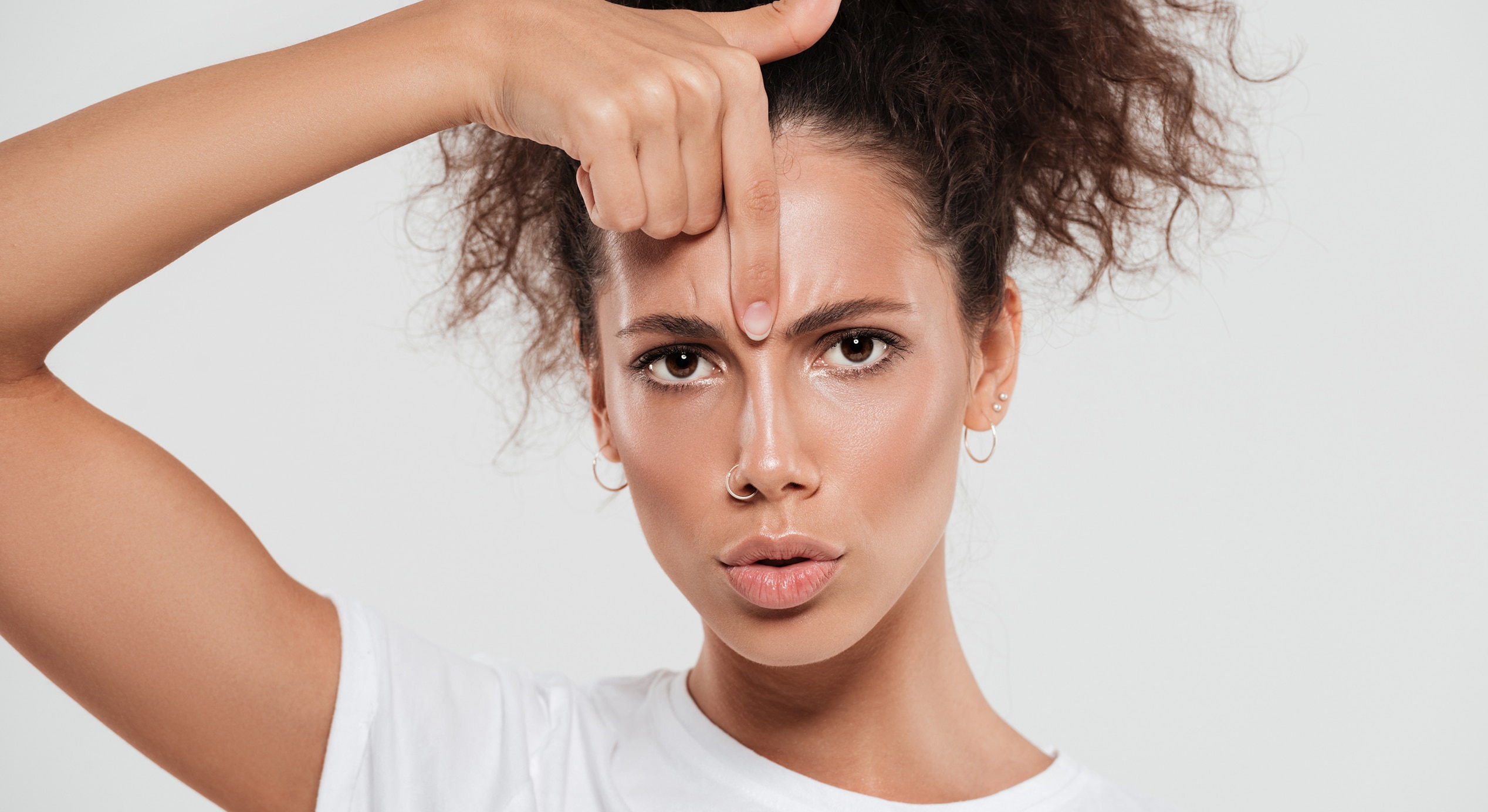 Pretty young woman with curly hair with forefinger 1