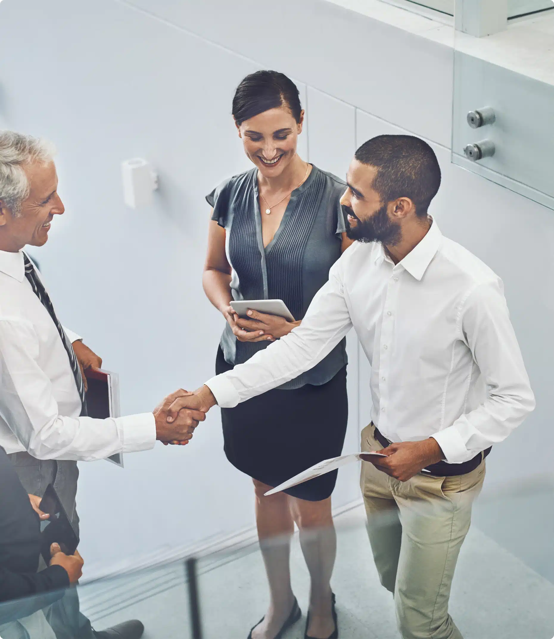 Three professionals greeting in a hospital corridor