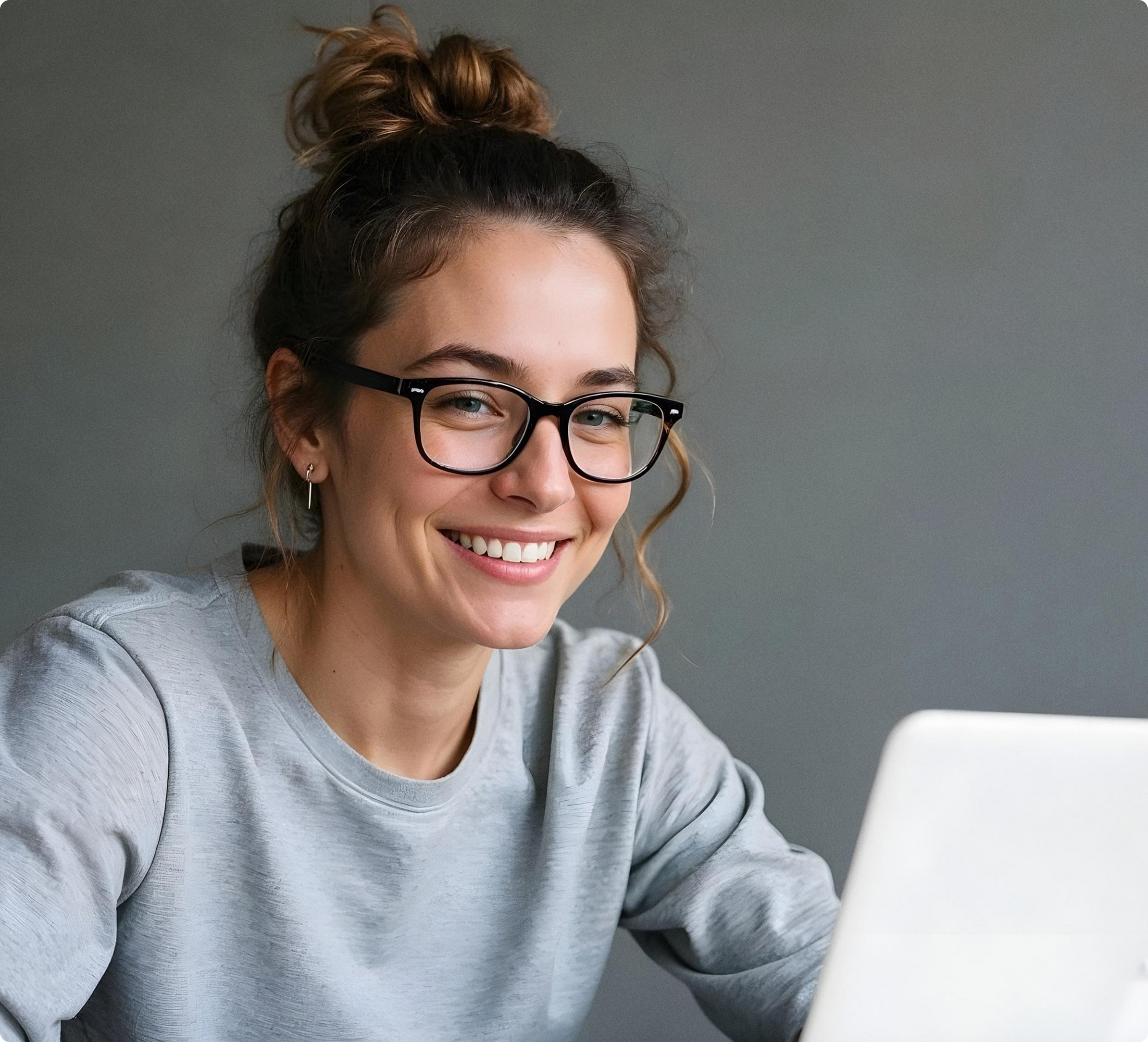 Woman smiling while working laptop minimalist home office 1
